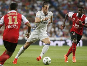 epa05490993 Real Madrid´s Welsh forward Gareth Bale (C) controls the ball between Stade de Reims players during the Santiago Bernabeu Trophy soccer match between Real Madrid and Stade de Reims at Santiago Bernabeu stadium in Madrid, Spain, 16 August 2016.  EPA/MARISCAL