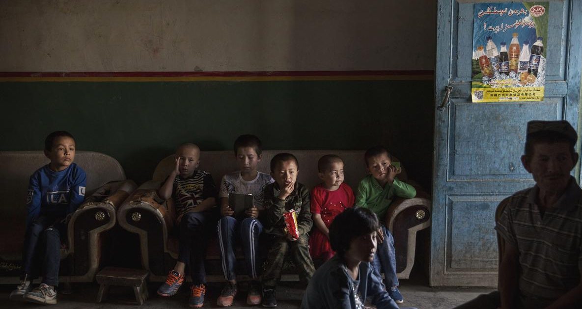 TURPAN, CHINA - SEPTEMBER 12: (CHINA OUT) Uyghur children watch a television program on the morning of the Corban Festival on September 12, 2016 in Turpan County, in the far western Xinjiang province, China. The Corban festival, known to Muslims worldwide as Eid al-Adha or 'feast of the sacrifice', is celebrated by ethnic Uyghurs across Xinjiang, the far-western region of China bordering Central Asia that is home to roughly half of the country's 23 million Muslims. The festival, considered the most important of the year, involves religious rites and visits to the graves of relatives, as well as sharing meals with family. Although Islam is a 'recognized' religion in the constitution of officially atheist China, ethnic Uyghurs are subjected to restrictions on religious and cultural practices that are imposed by China's Communist Party. Ethnic tensions have fueled violence that Chinese authorities point to as justification for the restrictions. (Photo by Kevin Frayer/Getty Images)