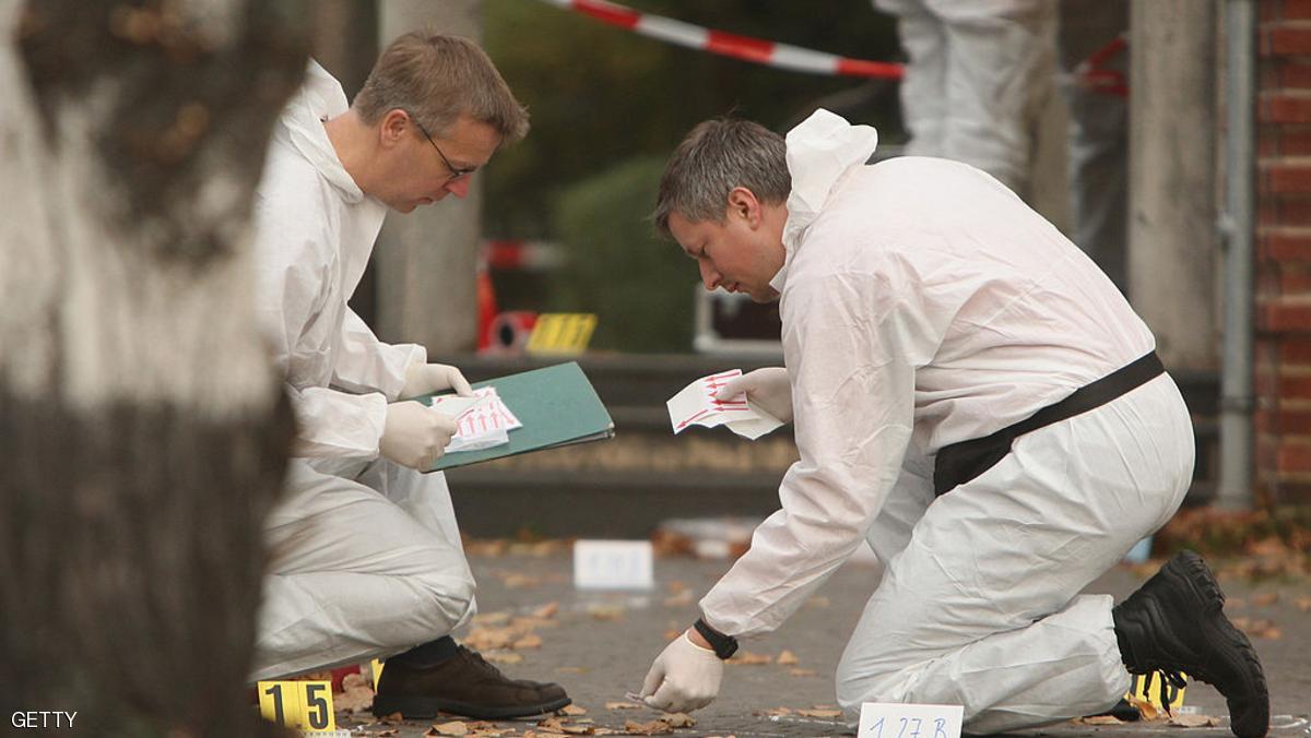 BERLIN, GERMANY - OCTOBER 29: Investigators search for clues outside a branch of Postbank bank after an attempted robbery that left one guard dead October 29, 2007 in Berlin, Germany. According to police three men ambushed a guard carrying money as he stepped out of an arriving armoured money transporter. An exchange of gun fire erupted between the guard an the robbers, in which the guard was fatally wounded and at least one robber was injured. The driver of the money transport pursued the fleeing robbers and rammed their car, though they managed to escape. (Photo by Sean Gallup/Getty Images)