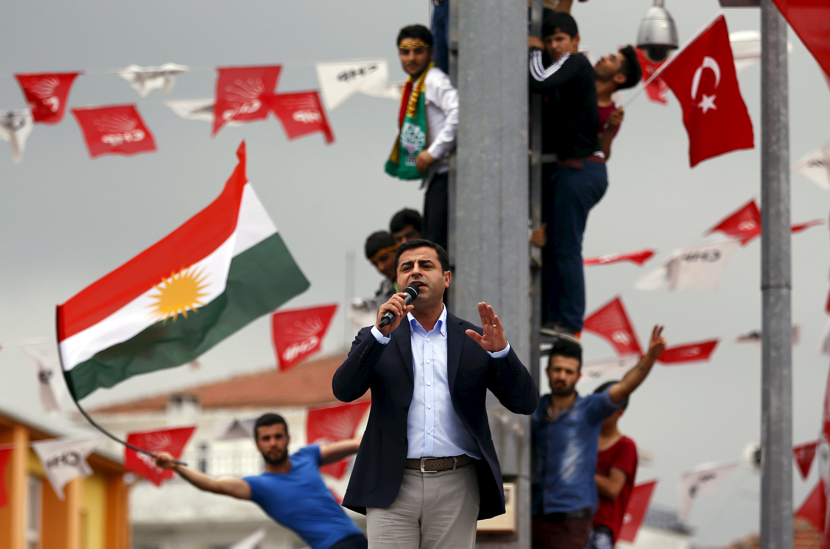 Selahattin Demirtas, co-chairman of the pro-Kurdish Peoples' Democratic Party (HDP), speaks as his supporters wave Kurdish (L) and Turkish national (R) flags in the background, during an election rally for Turkey's June 7 parliamentary election, in Istanbul, Turkey, June 6, 2015. Turkey's Kurdish-rooted opposition party, which could scupper Tayyip Erdogan's ambitions for sweeping new powers, accused the President on Saturday of a lack of respect for supporters killed in a bomb attack in an election rally and demanded he apologise. REUTERS/Murad Sezer