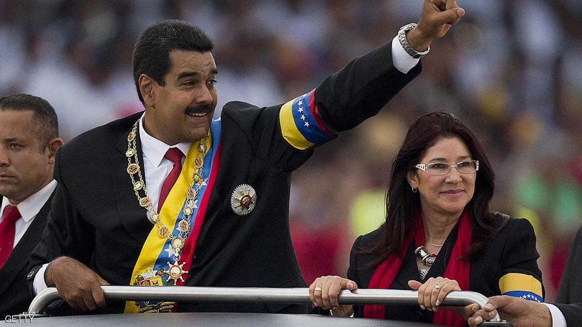 (FILLES) Venezuelan President Nicolas Maduro waves to the crowd next to his wife Cilia Flores during a motorcade after his installation in Caracas on April 19, 2013. On October 19 2013 Maduro will celebrate his first six months in power. AFP PHOTO/Luis Acosta (Photo credit should read LUIS ACOSTA/AFP/Getty Images)