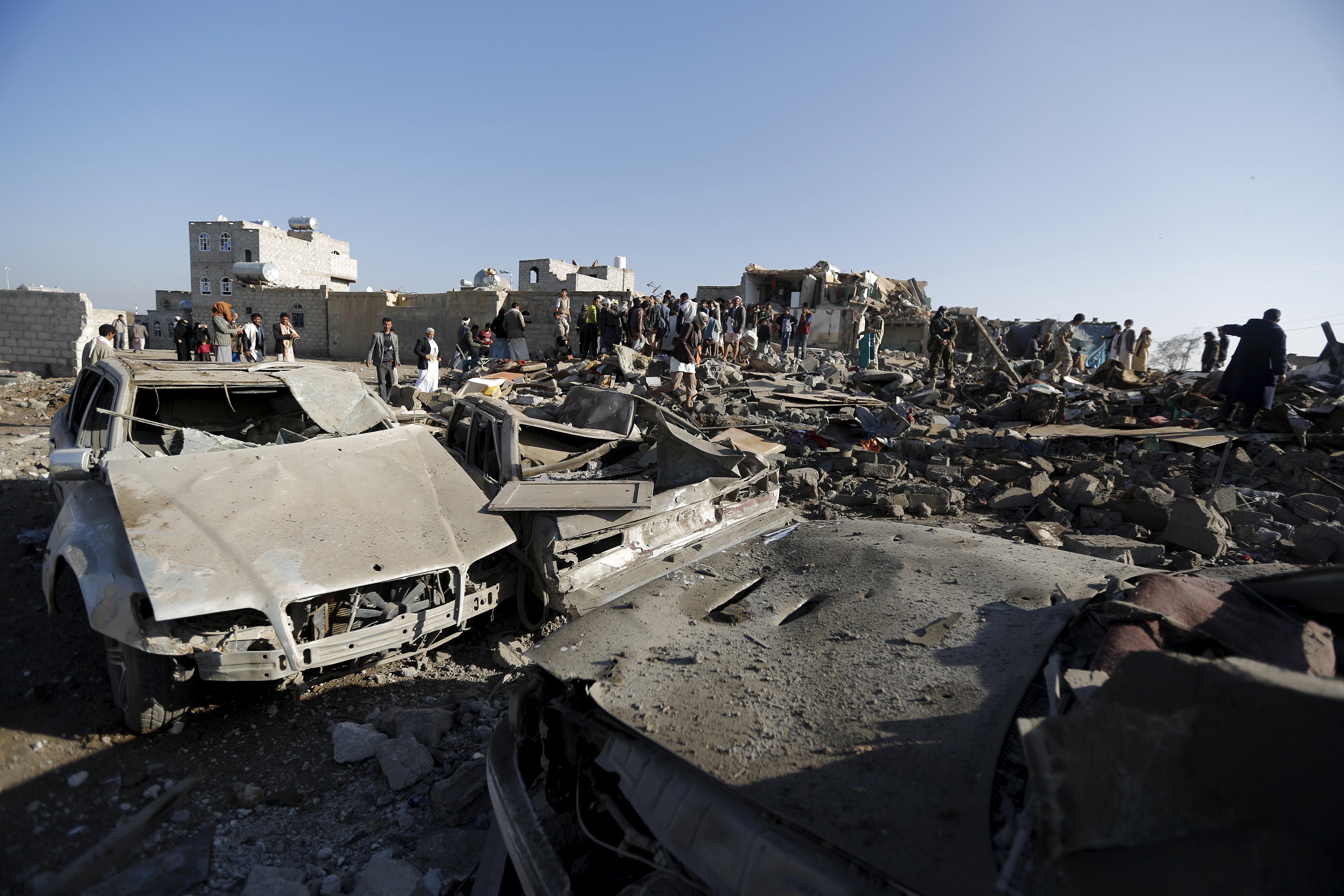 People gather at the site of an air strike at a residential area near Sanaa Airport March 26, 2015. Saudi Arabia and Gulf region allies launched military operations including air strikes in Yemen on Thursday, officials said, to counter Iran-allied forces besieging the southern city of Aden where the U.S.-backed Yemeni president had taken refuge. REUTERS/Khaled Abdullah