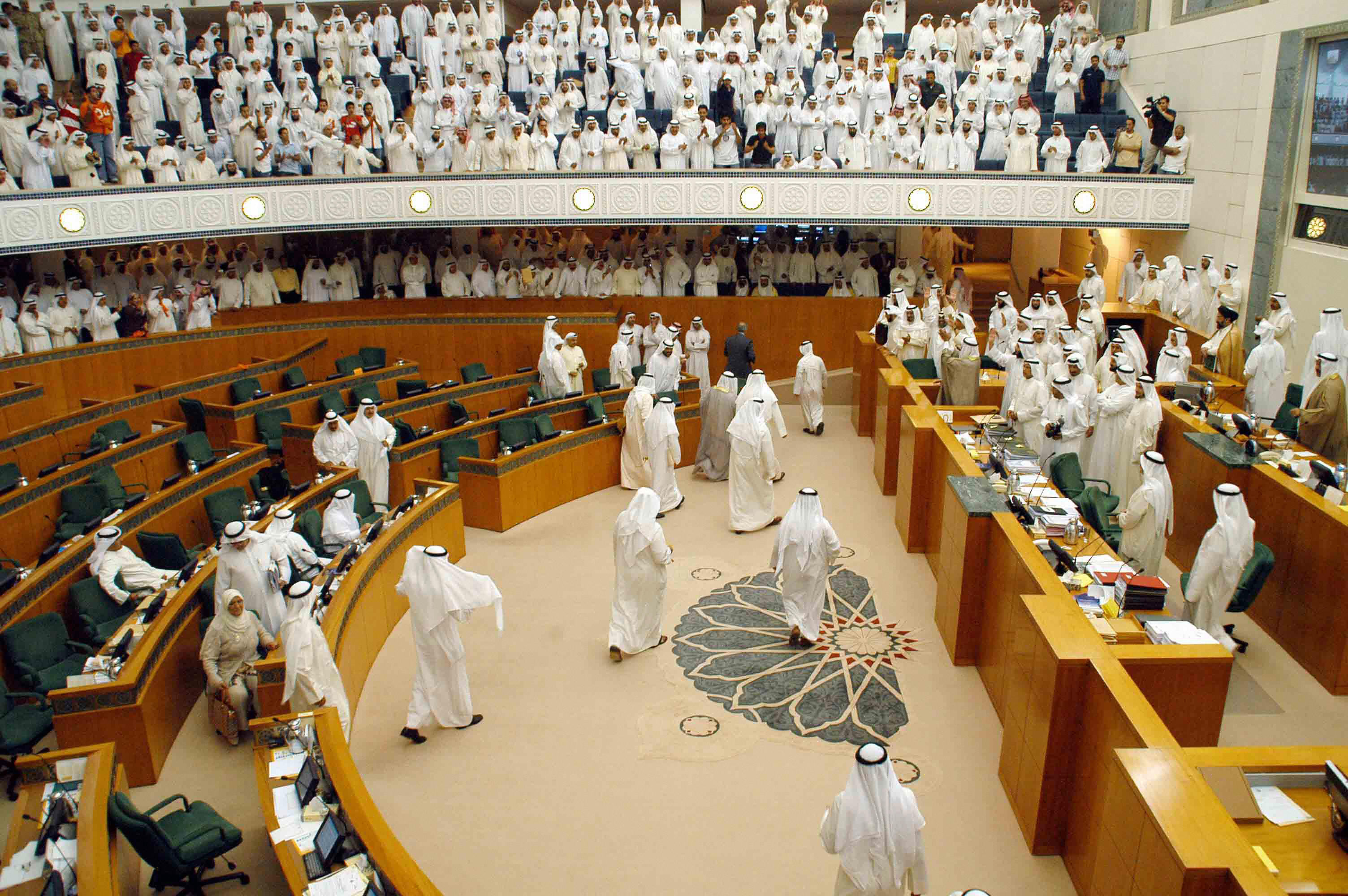 kuwait city, KUWAIT: A number of Kuwaiti MPs walk out of the parliament in Kuwait City 15 May 2006 in protest at attempts to block a redrawing of constituencies intended to counter alleged vote-buying. The Kuwaiti parliament broke up in chaos as reformist deputies left the session when voting began on a motion tabled by conservative and tribal MPs that sought to refer a government-backed bill reducing the number of consituencies from 25 to 10 to the constitutional court. EDS NOTE: Adding byline. AFP PHOTO/YASSER AL-ZAYYAT (Photo credit should read YASSER AL-ZAYYAT/AFP/Getty Images)