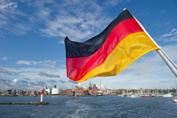 Die deutsche Flagge weht am 09.08.2012 an einem Schiff der Reederei Hiddensee vor der Silhouette der historischen Altstadt von Stralsund. Die Ostsee-Insel Hiddensee, die seit 1990 zum Nationalpark Vorpommersche Boddenlandschaft gehört, befindet sich westlich von der Insel Rügen. Hiddensee, auch "Perle der Ostsee" genannt ist 16,8 Quadratkilometer groß. Auf der 18,5 km langen und teils nur 300 Meter schmalen Insel leben nur etwa 1.500 Menschen. Kraftfahrzeuge sind nicht zugelassen. Foto: Stefan Sauer