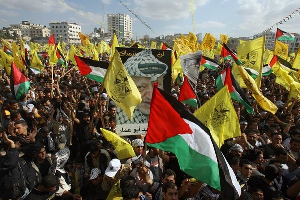Palestinian supporters of the secular Fatah movement shout slogans and wave their national and party's flags (yellow) during a huge gathering in Gaza city, 12 November 2007, to mark the anniversary of the death of Yasser Arafat. Hamas police killed six people in Gaza City today as hundreds of thousands gathered to commemorate the death Arafat in the biggest Fatah party rally since it was ousted by the Islamists. Another 130 people were wounded when the Hamas-run police force opened fire as crowds threw rocks and chanted "Shiite, Shiite" -- accusing them of being a proxy for Shiite Iran and its ally Syria, witnesses and medics said. AFP PHOTO/MOHAMMED ABED (Photo credit should read MOHAMMED ABED/AFP/Getty Images)