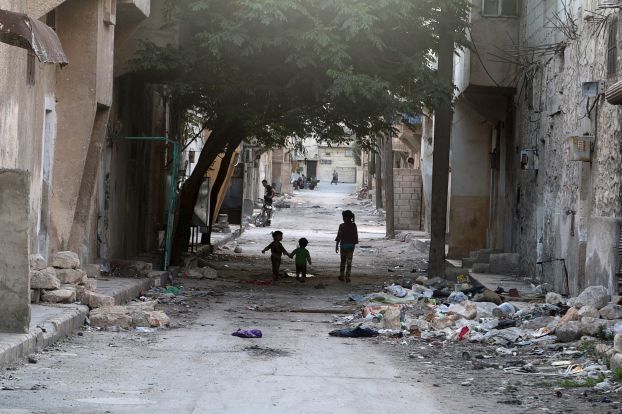 Children walk near garbage in al-Jazmati neighbourhood of Aleppo, Syria April 22, 2016. REUTERS/Abdalrhman Ismail