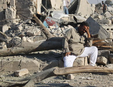 A Syrian man cries as he sits on the rubble of a building following a reported barrel-bomb attack by Syrian government forces on August 11, 2014 in the northern Syrian city of Aleppo. Syrian regime forces dumped barrel bombs today on a rebel-held area of Aleppo killing 10 civilians, including a family of four, a monitoring group said. AFP PHOTO / BARAA AL-HALABI
