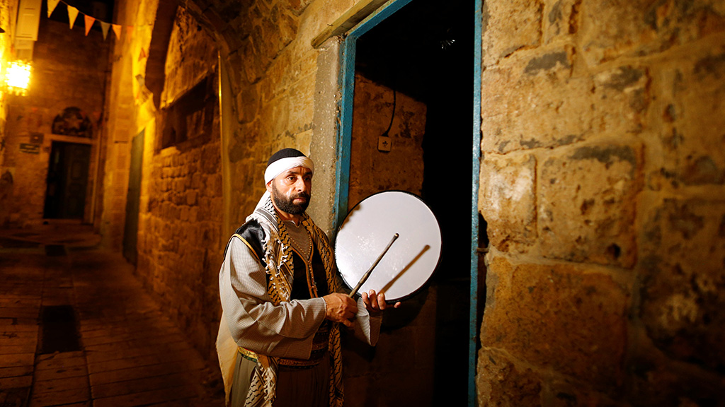 Michel Ayoub, a Christian Israeli-Arab, holds his drum as he performs the role of "Musaharati", the traditional custom of rousing Muslims up for their meal before daybreak, during the holy month of Ramadan in the Old City of the northern Israeli city of Arce June 20, 2016. REUTERS/Ammar Awad