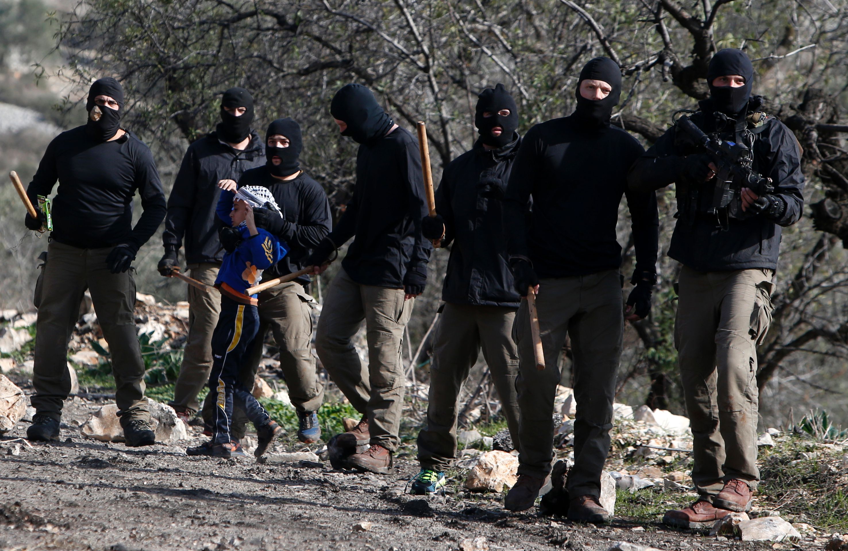 Masked members of the Israeli security forces briefly detain a Palestinian boy during clashes following a demonstration against the expropriation of Palestinian land by Israel in the village of Kfar Qaddum, near Nablus, in the occupied West Bank on December 23, 2016. / AFP / JAAFAR ASHTIYEH