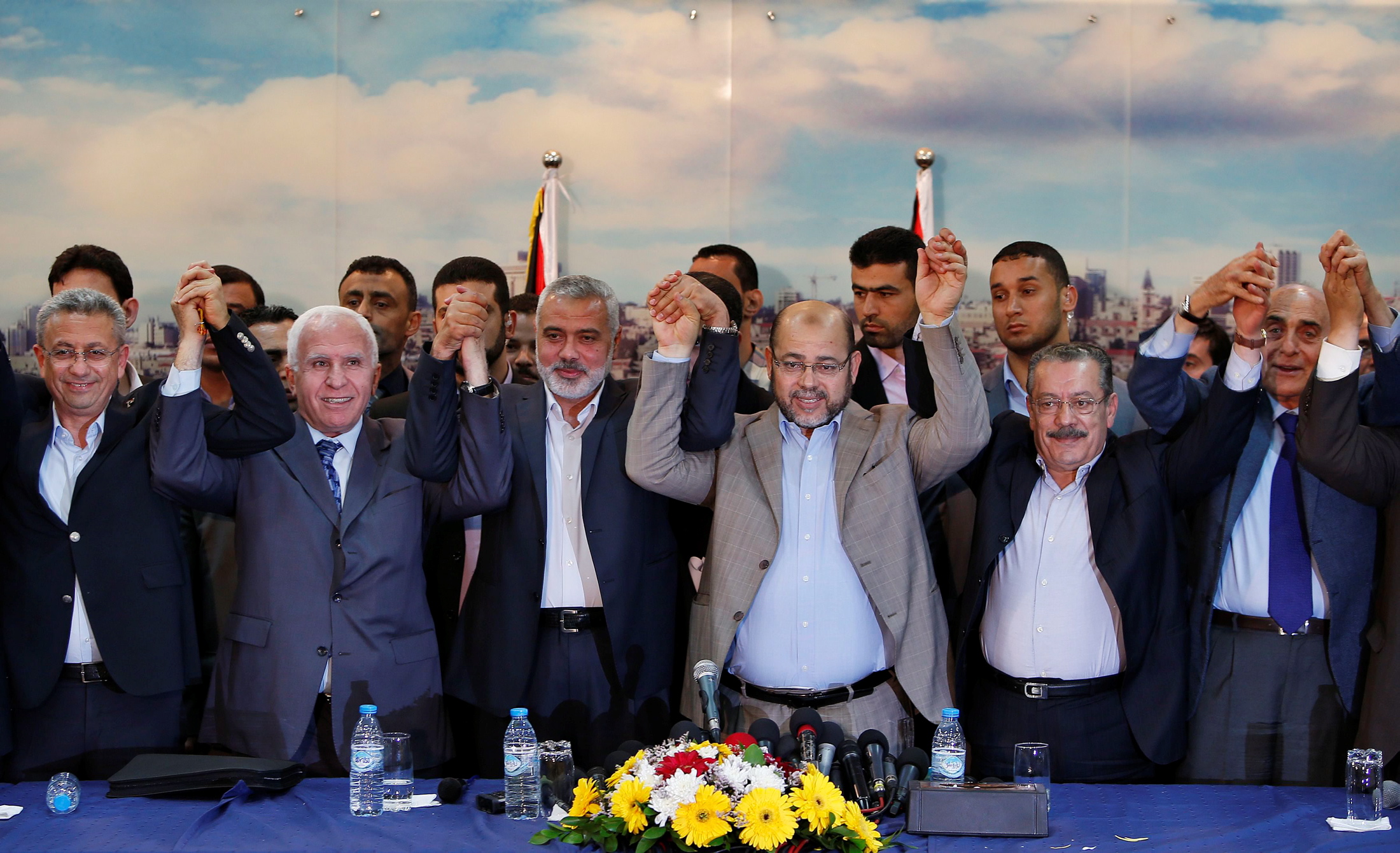 Senior Fatah official Azzam Al-Ahmed (2nd L), head of the Hamas government Ismail Haniyeh (3rd L) and senior Hamas leader Moussa Abu Marzouq (4th L) , hold their hands after announcing a reconciliation agreement in Gaza City April 23, 2014. The Gaza-based Islamist group Hamas and President Mahmoud Abbas's Palestine Liberation Organization (PLO) agreed on Wednesday to implement a unity pact, both sides announced in a joint news conference.REUTERS/Suhaib Salem (GAZA - Tags: MILITARY POLITICS TPX IMAGES OF THE DAY) ארגון חמאס ו פתח חתמו על הסכם ליישום הפיוס ביניהם טקס חתימה ב עזה