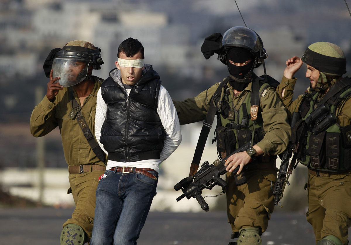 Israeli soldiers arrest a Palestinian during clashes with Israeli troops at a protest against the Jewish settlement of Ofra, in the West Bank village of Silwad, near Ramallah January 17, 2014. REUTERS/Mohamad Torokman (WEST BANK - Tags: POLITICS CIVIL UNREST MILITARY TPX IMAGES OF THE DAY) ORG XMIT: SJS08
