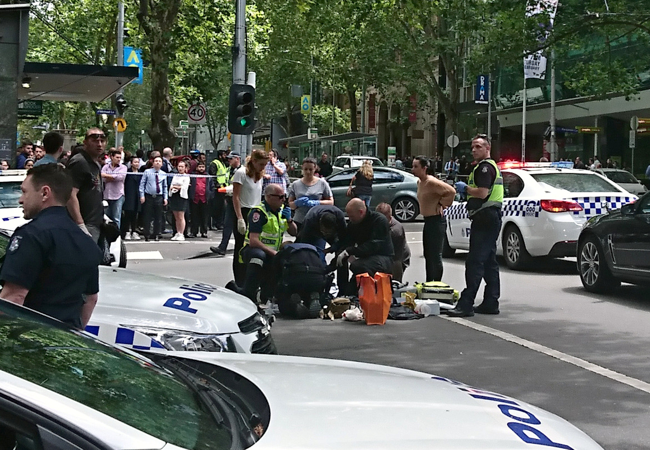 Members of the public watch as police and emergency services attend to an injured person after a car hit pedestrians in central Melbourne, Australia, January 20, 2017. AAP/Luke Costin/via REUTERS ATTENTION EDITORS - THIS IMAGE WAS PROVIDED BY A THIRD PARTY. EDITORIAL USE ONLY. NO RESALES. NO ARCHIVE. AUSTRALIA OUT. NEW ZEALAND OUT. TPX IMAGES OF THE DAY