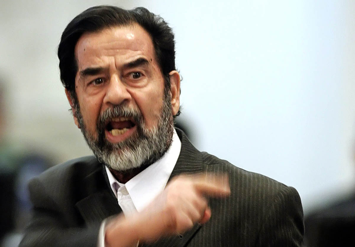 Former Iraqi President Saddam Hussein gestures during his trial held under tight security in Baghdad's heavily fortified Green Zone, 06 December 2005. Saddam and seven others face charges that they ordered the killing in 1982 of nearly 150 people in the mainly Shiite village of Dujail, north of Baghdad, after a failed attempt on the former dictator's life. AFP PHOTO/POOL Stefan Zaklin
