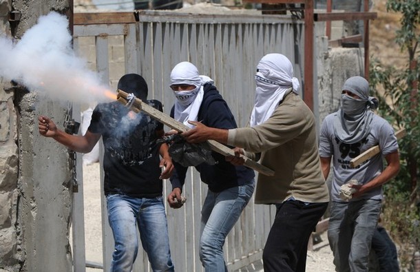 Masked Palestinian youths fire a makeshift bomb towards Israeli forces during clashes following Friday prayer in Arab east Jerusalem on May 13, 2011 as Israeli police flooded the streets of Jerusalem, fearing violence as Palestinians began marking the "Nakba" or "catastrophe" which befell them following Israel's establishment in 1948. AFP PHOTO/AHMAD GHARABLI (Photo credit should read AHMAD GHARABLI/AFP/Getty Images)
