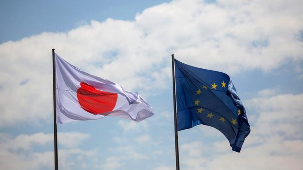 The Japanese national flag, left, flies beside the European Union (EU) flag as Shinzo Abe, Japan's prime minister, and Angela Merkel, Germany's chancellor, hold a news conference at the Chancellery in Berlin, Germany, on Wednesday, April 30, 2014. Merkel and Abe spoke about their economic ties, communications with Russia and de-escalating the crisis in Ukraine. Photographer: Krisztian Bocsi/Bloomberg