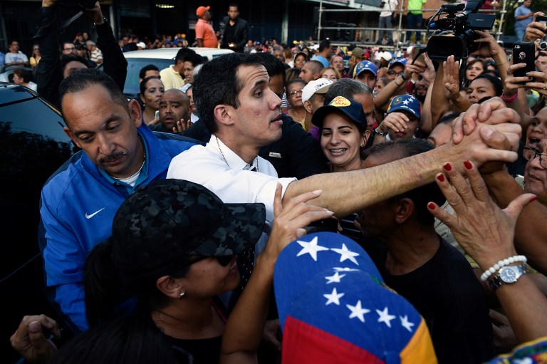 Venezuela's National Assembly president Juan Guaido greets supporters during an open meeting at the Caricuao neighborhood in southwest Caracas, on January 19, 2019. (Photo by Federico PARRA / AFP)
