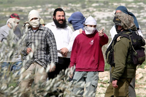 Israeli soldiers (R) try to disperse masked Jewish settlers from the Havat Gilad settlement, who were throwing stones at Palestinian villagers, near Farata, east of the West Bank ciy of Qalqilya, on February 28, 2012. AFP PHOTO/JAAFAR ASHTIYEH (Photo credit should read JAAFAR ASHTIYEH/AFP/Getty Images)