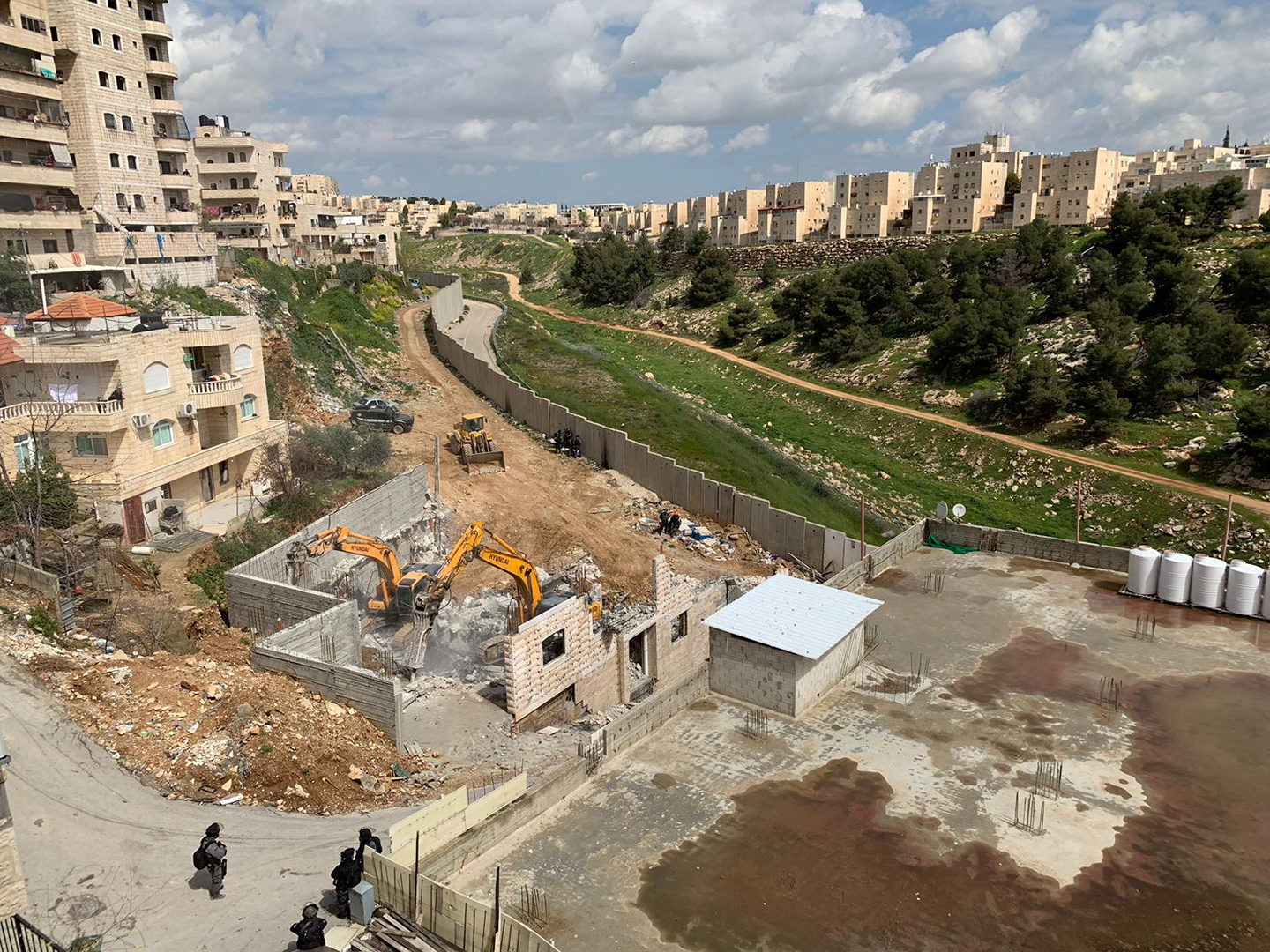 القدس - جرافات وآليات الاحتلال تهدم مبنى من طابقين بمخيم شعفاط-0