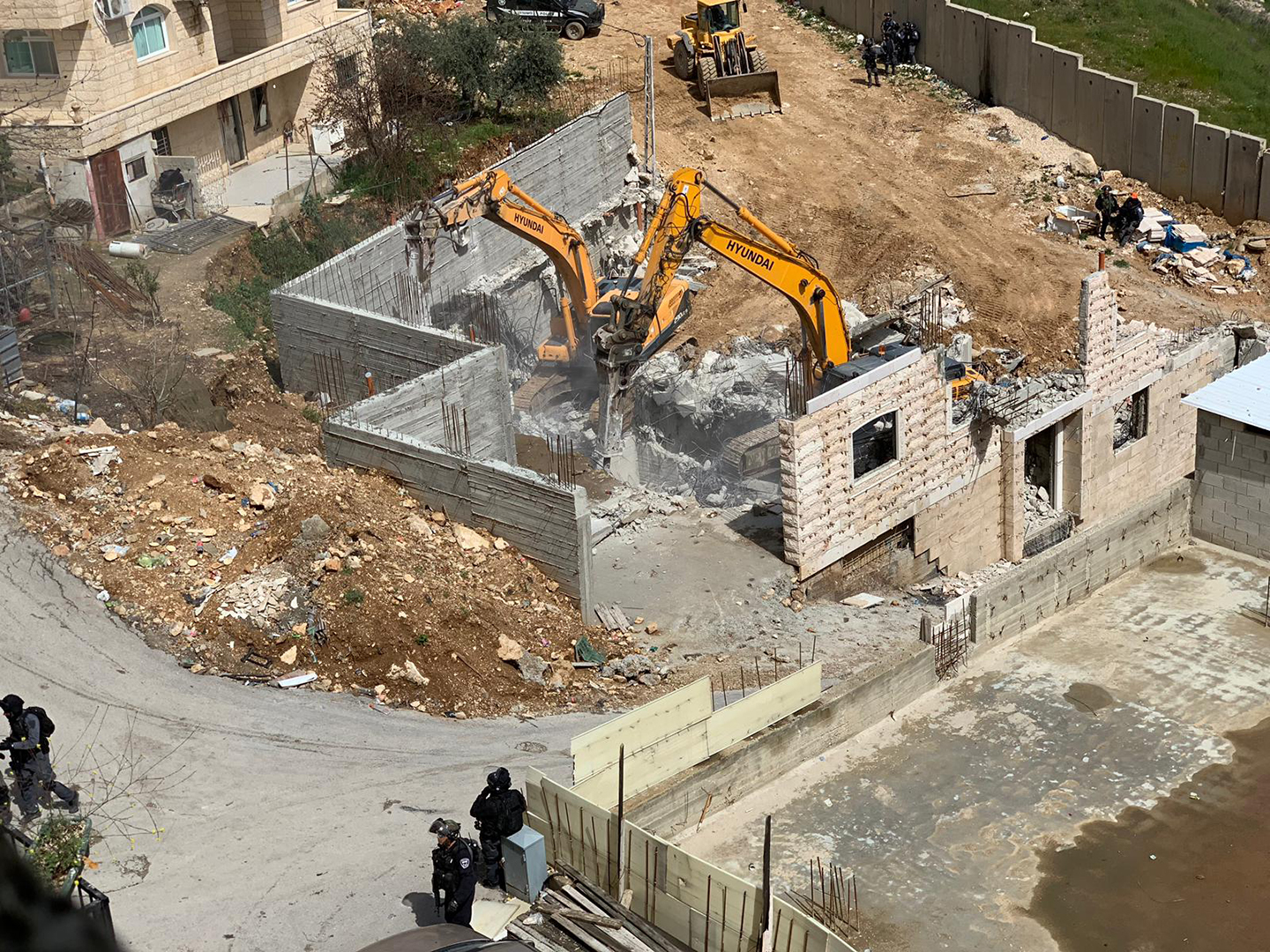 القدس - جرافات وآليات الاحتلال تهدم مبنى من طابقين بمخيم شعفاط