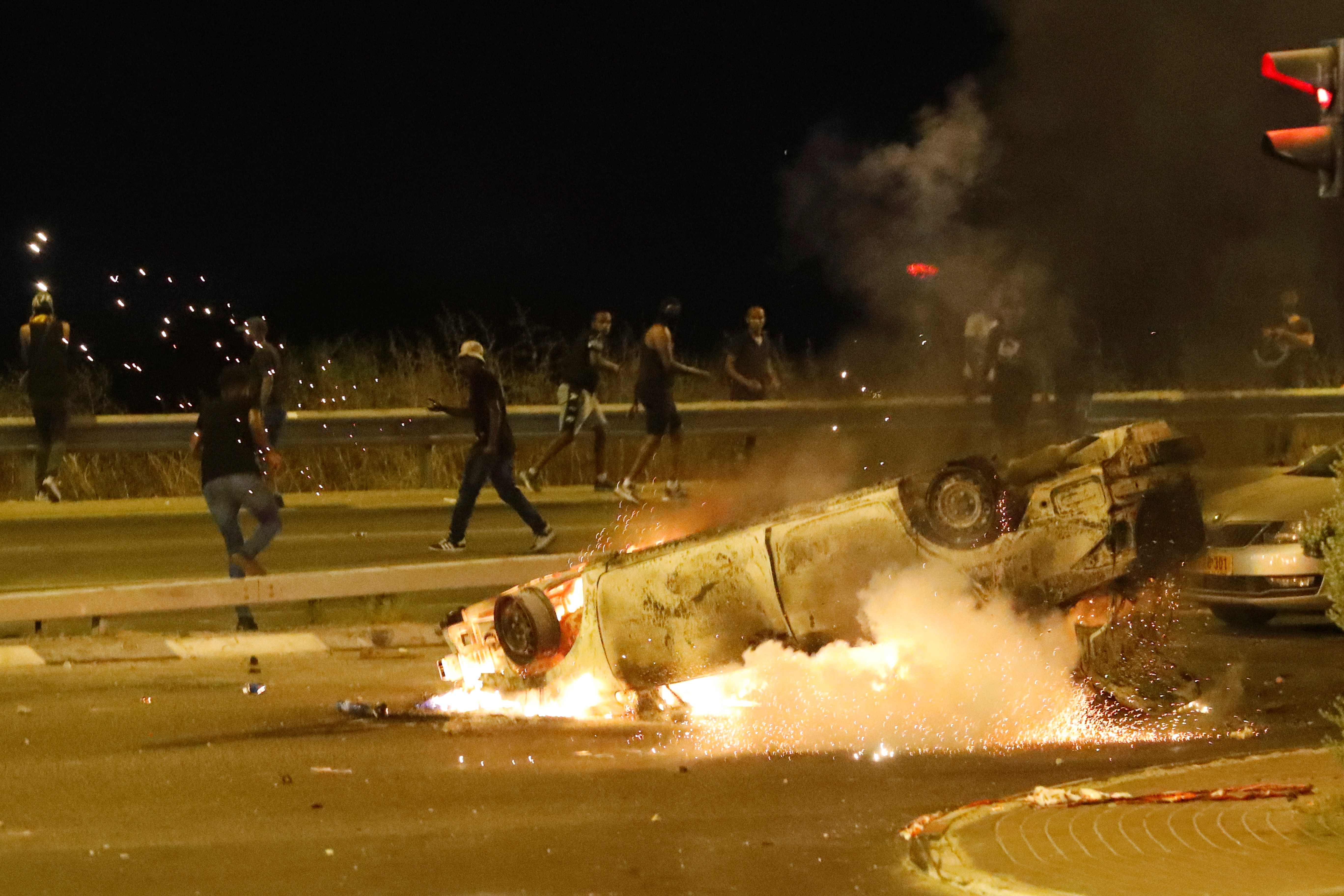 Members of the Ethiopian community of Israel clash with the police during in the Israeli coastal city of Netanya on July 2, 2019, during a protest against the killing of Solomon Tekah, a young man of Ethiopian origin, who was killed by an off-duty police officer. Angry protesters clashed with Israeli police on July 2 over an off-duty officer's killing of a young man of Ethiopian origin, as the incident drew fresh accusations of racism. Crowds of Ethiopian Israelis battled police and blocked highways on at least 15 junctions across the country, with 47 officers wounded and 60 demonstrators detained, according to a police statement. Solomon Teka, reportedly 18 or 19, was buried on July 2, after he was shot dead in Kiryat Haim, a town near the northern port city of Haifa, late Sunday. / AFP / JACK GUEZ
