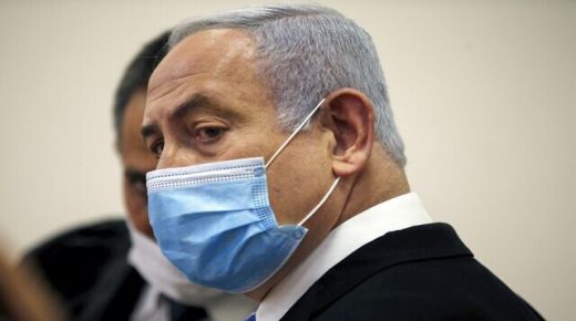 Israeli Prime Minister Benjamin Netanyahu, wearing a protective face maks, is pictured inside a courtroom at the district court of Jerusalem on May 24, 2020, during the first day of his corruption trial. - Fresh from forming a new government after more than 500 days of electoral deadlock, Netanyahu is expected to begin a new battle in the Jerusalem District Court -- to stay out of prison. The 70-year-old was scheduled to appear at a court hearing to formally confirm his identity to judges, after being indicted in January for bribery, fraud and breach of trust. (Photo by RONEN ZVULUN / POOL / AFP)
