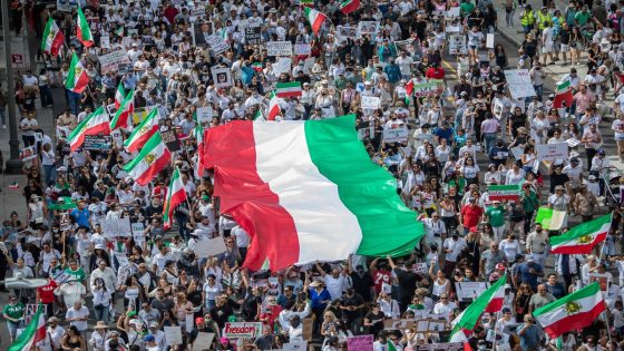 TOPSHOT - Demonstrators hold Iran's flag during a protest for Mahsa Amini who died in custody of Iran's morality police, in Los Angeles, California, on October 1, 2022. Amini's death after her arrest by Iran's morality police has sparked a wave of unrest since the 22-year-old died on September 16 after her arrest for allegedly failing to observe Iran's strict dress code for women. The street violence has led to the deaths of dozens of people -- mostly protesters but also members of the security forces -- and hundreds of arrests. (Photo by Apu GOMES / AFP)