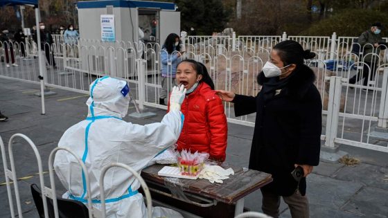 (FILES) This file photo taken on November 23, 2022 shows a health worker taking a swab sample from a girl to be tested for Covid-19 coronavirus at a collection station in Beijing. China's daily Covid cases have climbed to the highest since the pandemic began, official data showed on November 24, 2022, despite the government persisting with a zero-tolerance approach involving gruelling lockdowns and travel restrictions. (Photo by Jade GAO / AFP)