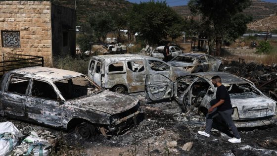 A man walks amidst burnt cars, reportedly set ablaze by Israeli settlers, in the area of in Al-Lubban Al-Gharbi in the occupied West Bank on June 21, 2023. Four people were shot and killed yesterday near a settlement in the occupied West Bank, Israeli officials said, a day after an army raid in the territory left six Palestinians dead. (Photo by AHMAD GHARABLI / AFP)