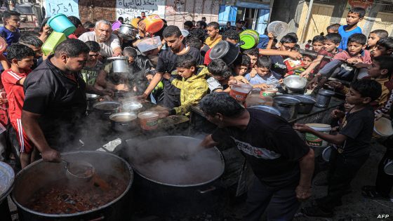 Palestinians queue to receive a portion of food at a make-shift charity kitchen in Rafah in the southern Gaza Strip, on November 8, 2023, amid the ongoing battles between Israel and the militant group Hamas. (Photo by SAID KHATIB / AFP)