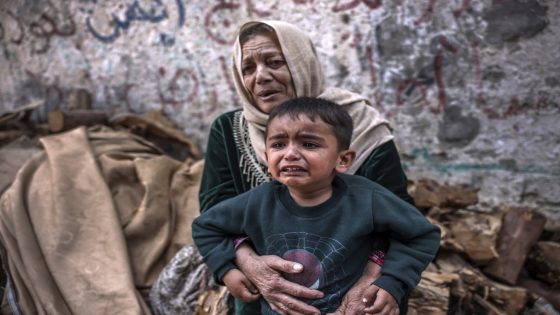 A child and a woman react following an Israeli air strike in Beit Lahia in the northern Gaza Strip, on May 13, 2023. - Israeli air strikes battered Gaza again on May 13 in response to rocket fire from militants as deadly fighting resumed after a night of relative calm, despite efforts to secure a truce. (Photo by MOHAMMED ABED / AFP)