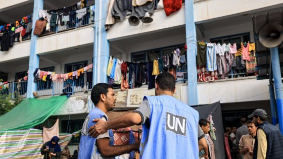Workers of the United Nations Relief and Works Agency for Palestine Refugees (UNRWA) agency talk together in the playground of an UNRWA-run school that has been converted into a shelter for displaced Palestinians in Khan Yunis in the southern Gaza Strip on October 25, 2023, amid the ongoing battles between Israel and the Palestinian group Hamas. (Photo by Mahmud HAMS / AFP)