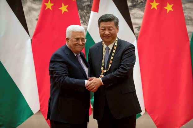 Palestinian President Mahmoud Abbas, left, shakes hands after presenting a medallion to Chinese President Xi Jinping, right, during a signing ceremony at the Great Hall of the People in Beijing, China, July 18, 2017.REUTERS/Mark Schiefelbein/Pool