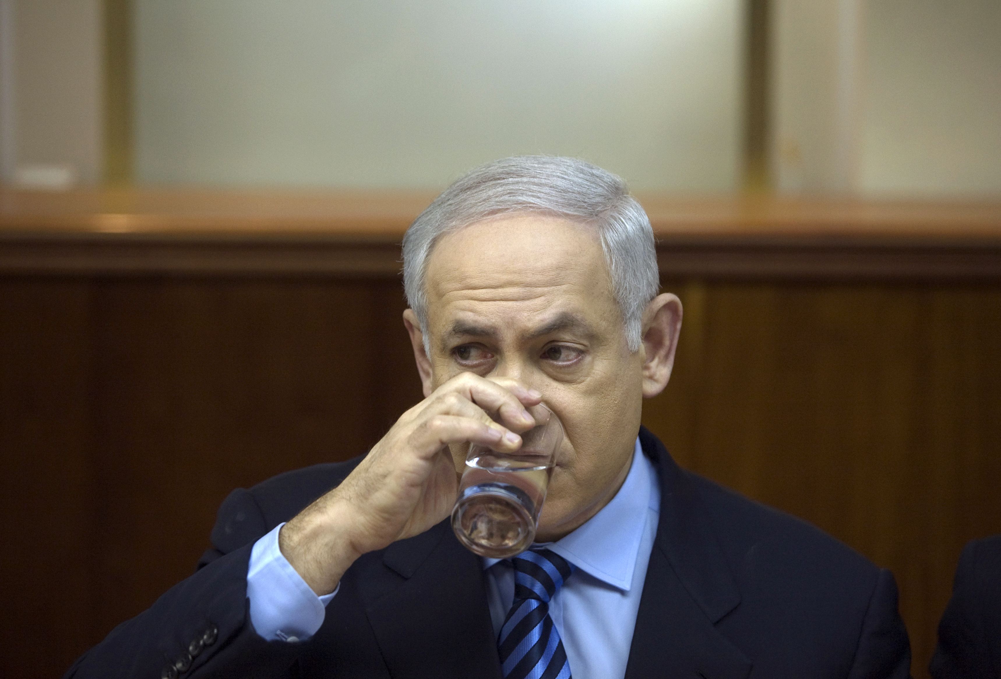 Israel's Prime Minister Benjamin Netanyahu drinks water during the weekly cabinet meeting in Jerusalem October 25, 2009. REUTERS/Baz Ratner (JERUSALEM POLITICS)