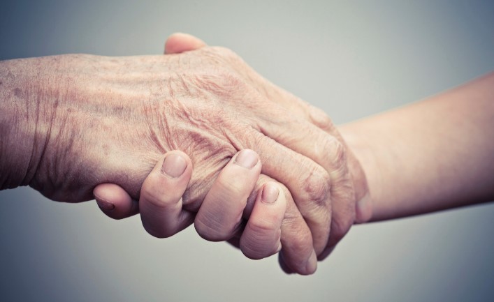 Elderly hand and caregiver