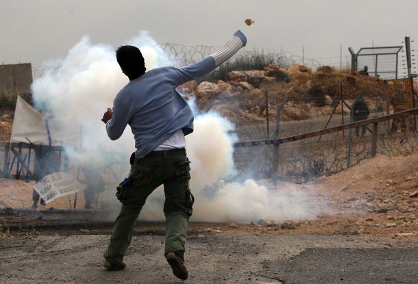 A Palestinian protester throws a stone towards Israeli forces during clashes that followed a demonstration against the controversial Israeli separation barrier in the West Bank village of Bilin, near Ramallah, on April 30, 2010. Israel says the network of steel and concrete walls, fences and barbed wire is needed for security while the Palestinians view it as a land grab that undermines their promised state. AFP PHOTO/ABBAS MOMANI (Photo credit should read ABBAS MOMANI/AFP/Getty Images)