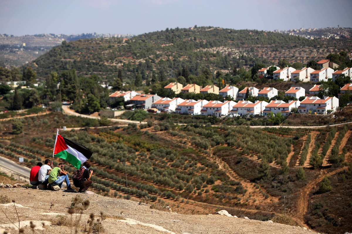 Palestinian protesters wave a national flag during a protest against Jewish settlements in the West Bank village of Nabi Saleh, near Ramallah August 28, 2015. Photo by Shadi Hatem