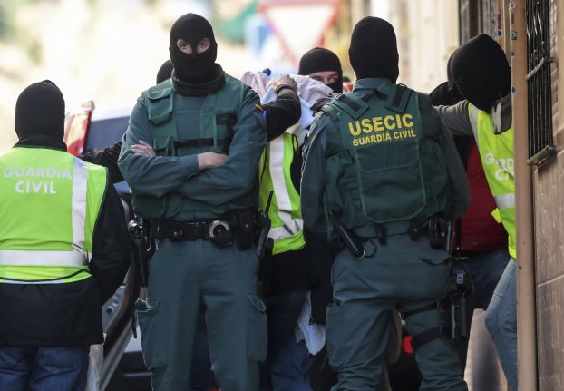 Spanish civil guard members lead a person arrested on suspicion of links to militant group Islamic State after a house search in Granada, southern Spain April 16, 2016. REUTERS/Pepe Marin EDITORIAL USE ONLY. NO RESALES. NO ARCHIVE TPX IMAGES OF THE DAY