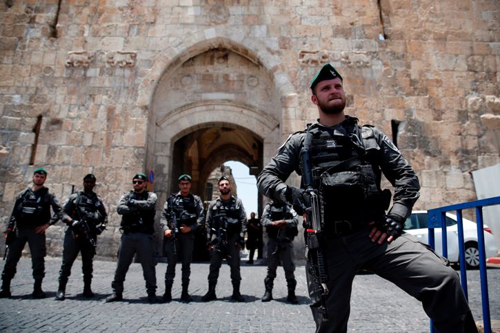 Israeli security forces stand guard as Palestinians worshippers demonstrate outside the Lion's Gate, a main entrance to Al-Aqsa mosque compound, due to newly-implemented security measures by Israeli authorities which include metal detectors and cameras, in Jerusalem's Old City on July 17, 2017.
Israel reopened the ultra-sensitive holy site, after it was closed following an attack by Arab Israeli men in which two Israeli policemen were killed. / AFP PHOTO / AHMAD GHARABLI