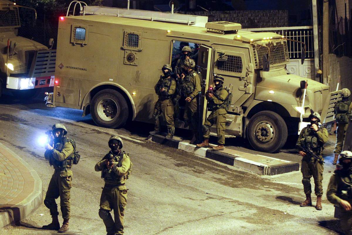 epa04302107 Israeli military patrols the streets in the West bank city of Hebron early 06 July 2014, during the ongoing search for the alleged kidnappers of three Israeli teenagers, who were found dead near Hebron on 30 June. Police are also investigating whether the death of a slain Palestinian youth was carried out by Israelis in revenge for the abduction and killing of the three Jewish teens. Further clashes erupted between police and protesters in East Jerusalem and in Arab villages in northern Israel, as Palestinians said the slain teenager was burned alive. EPA/ABED AL HASHLAMOUN