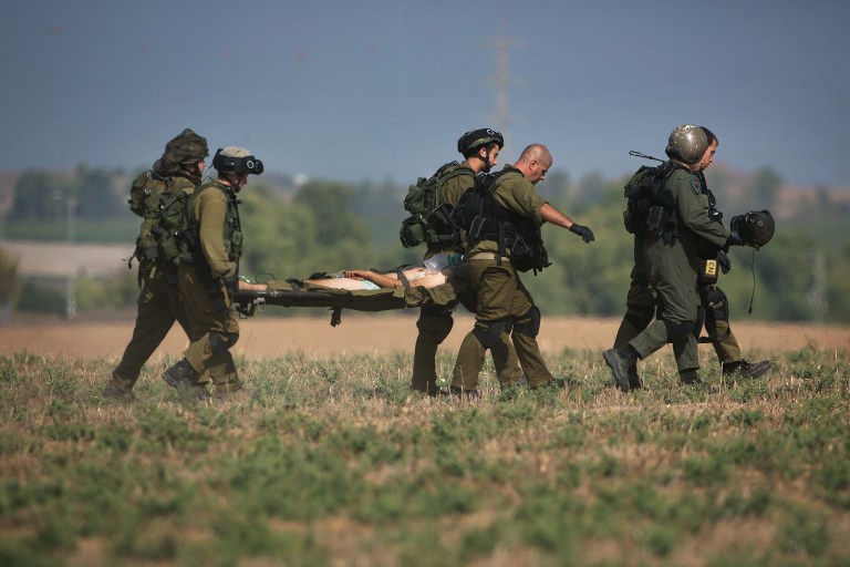 An injured Israeli soldier is evacuated from near the Israeli border with Gaza Strip on July 21, 2014, following heavy fights between Israeli soldiers to Palestinian militants. The UN Security Council called for an "immediate ceasefire" as Israel pressed on with a blistering assault on Gaza taking the Palestinian death toll above 500. The Israeli army said 13 soldiers were killed inside Gaza on July 21, raising to 18 the number of troops killed since the ground operation began late on July 17. AFP PHOTO/MENAHEM KAHANA