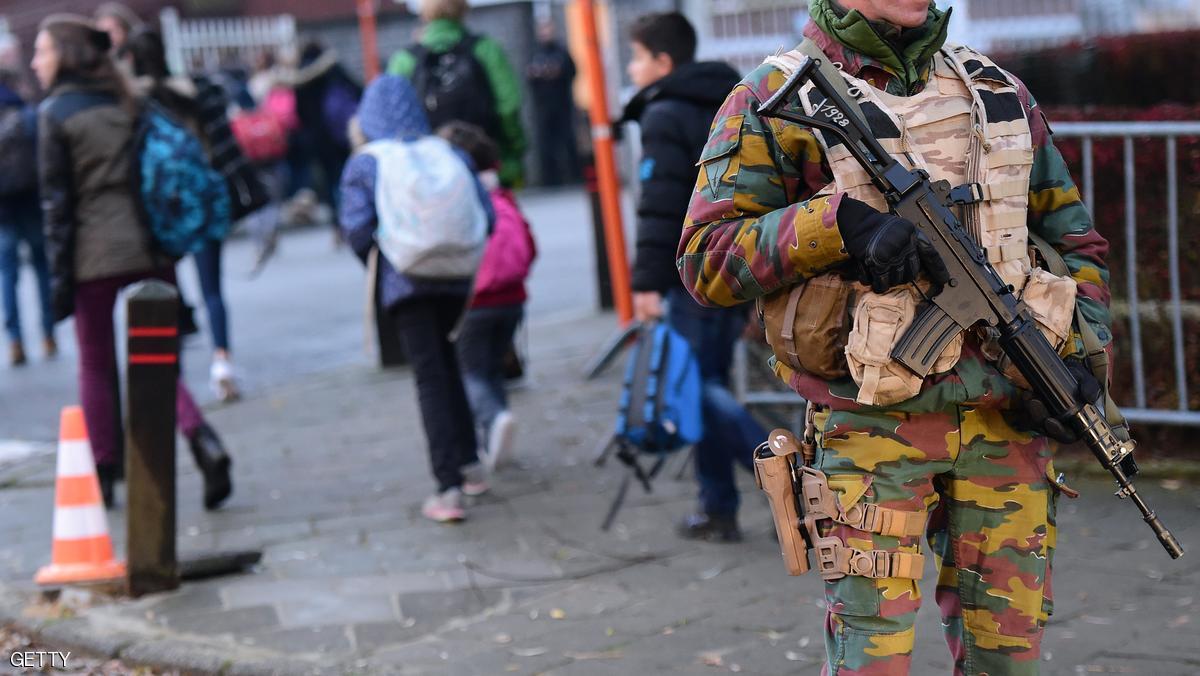 An armed soldier stand guards as pupils go to school at the French lycee in Brussels on November 25, 2015. Schools and some subway lines reopened after four days of lockdown, but the Belgian capital remains on the highest possible alert level for the fifth consecutive day under a maximum terror alert to find key Paris attacks suspects. AFP PHOTO / EMMANUEL DUNAND / AFP / EMMANUEL DUNAND (Photo credit should read EMMANUEL DUNAND/AFP/Getty Images)