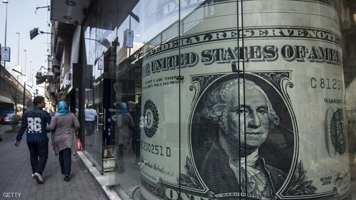 People walk past a currency exchange shop displaying a giant US dollars banknote in downtown Cairo on November 3, 2016.
Egypt floated the country's pound as part of a raft of reforms, after a dollar crunch and exorbitant black market trade threatened to grind some imports to a halt. / AFP / KHALED DESOUKI (Photo credit should read KHALED DESOUKI/AFP/Getty Images)
