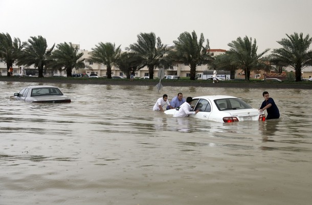 Saudi men try to men push a car submerged in water on a flooded road following a heavy rain storm that hit the Saudi capital Riyadh on May 3, 2010. Heavy rains in Saudi Arabia caused flooding, traffic jams and auto accidents with many drivers trapped on main roads by high waters. AFP PHOTO/STR (Photo credit should read -/AFP/Getty Images)