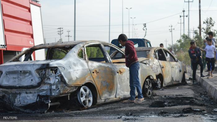 A man looks at a burnt car at the site of a suicide car bomb attack of a wedding in the town of Ameriyat Falluja, Iraq November 18, 2016. REUTERS/Stringer