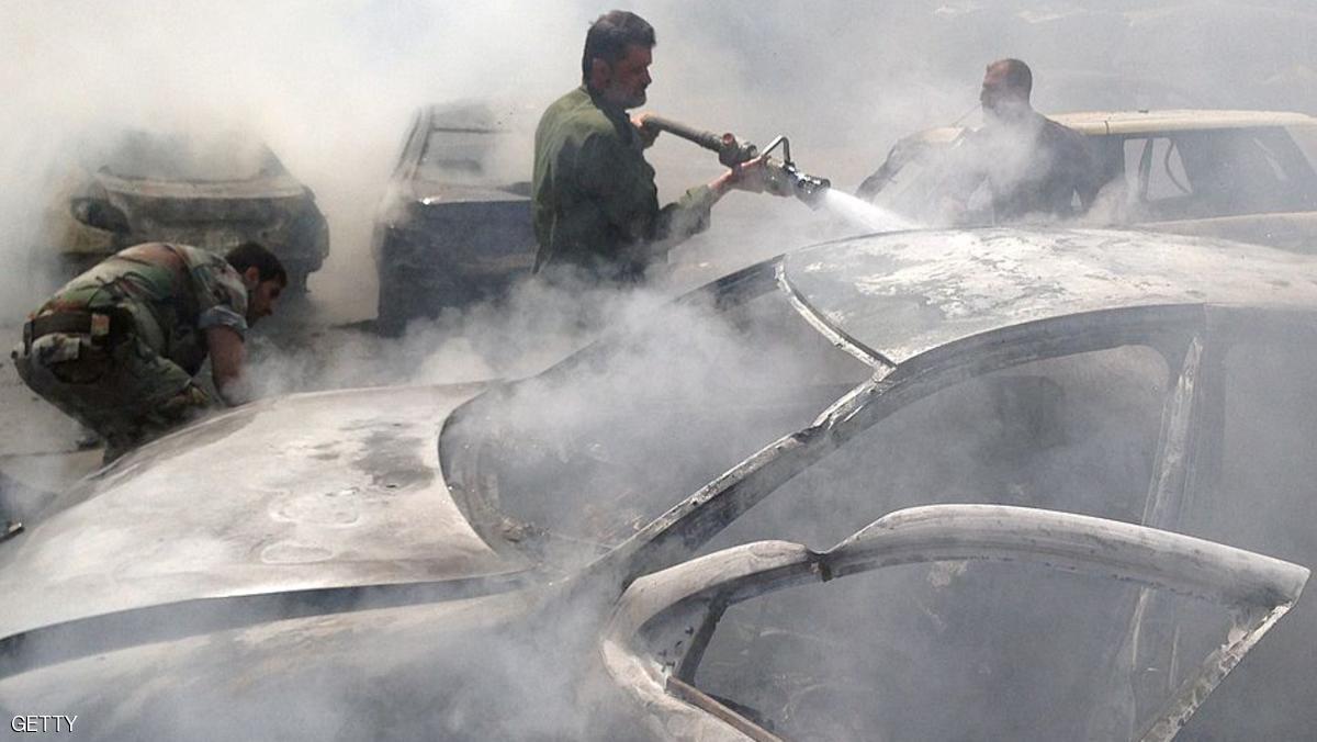 A picture taken with a smartphone on May 25, 2014, shows emergency teams extinguishing a fire at the site of a car bomb attack in a regime-held area in Syria's central city of Homs, that left at least eight people dead and tens injured, according to the governor of Homs. For two years, Assad's forces bombarded insurgents holed up inside the city before the siege was finally lifted at the beginning of May, and the last rebel holdouts left the area under an evacuation deal that handed the Old City back to the government. AFP PHOTO/SAM SKAINE (Photo credit should read SAM SKAINE/AFP/Getty Images)